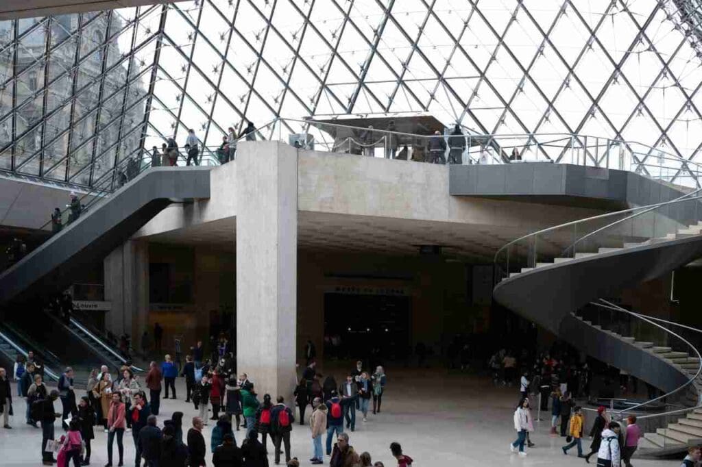 Foto de pessoas andando dentro de um edifício de concreto