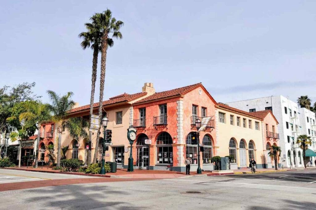 Foto de casa rosada com palmeiras em uma esquina