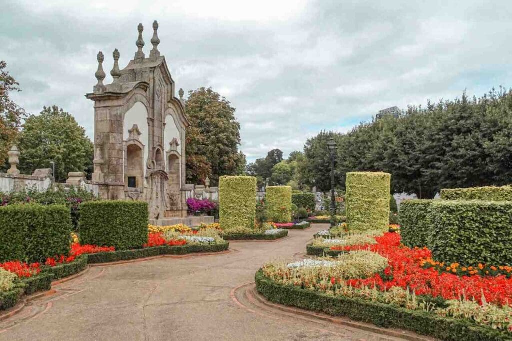 Foto de um jardim colorido com um monumento ao fundo