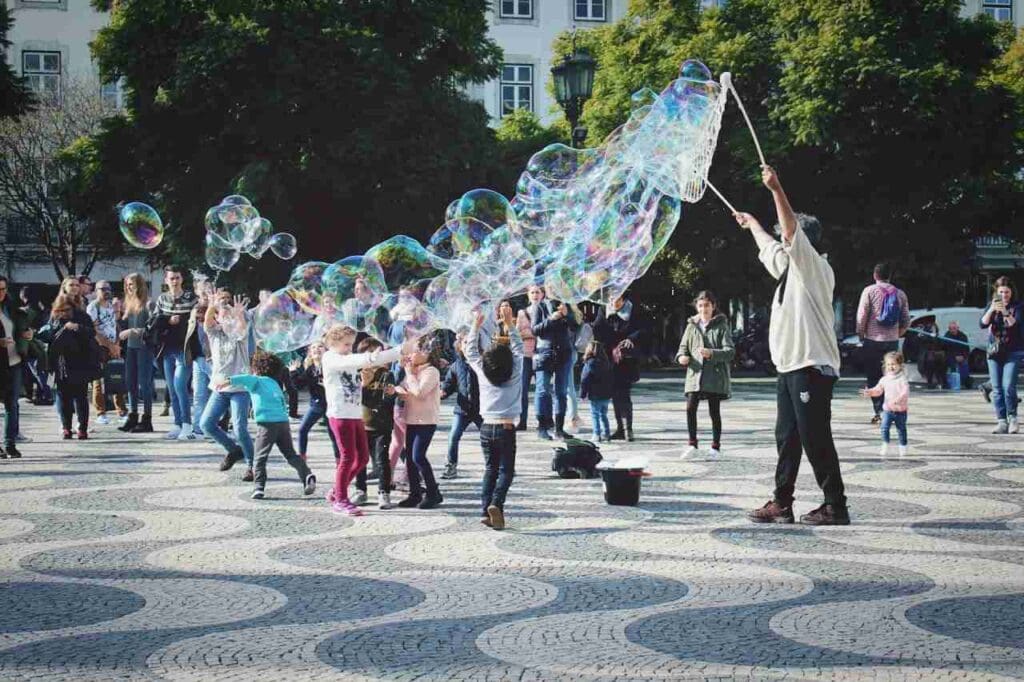 Foto de crianças brincando com bolhas de sabão no parque