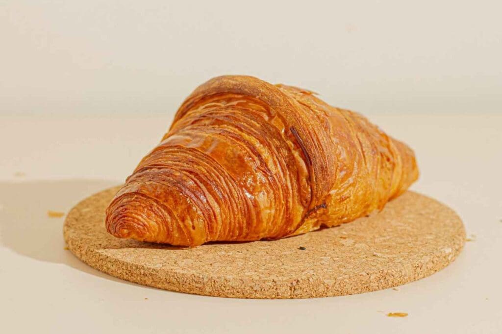 Foto de um croissant sentado em cima de uma rodela de cortiça