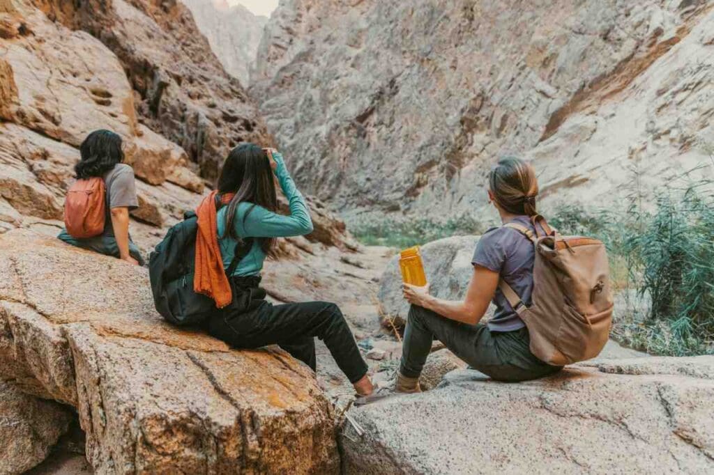 Foto de pessoas descansando em meio a pedras na montanha