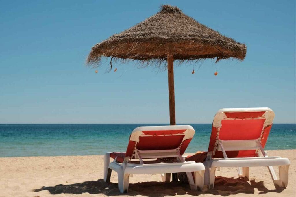 Foto de duas cadeiras em cima da areia