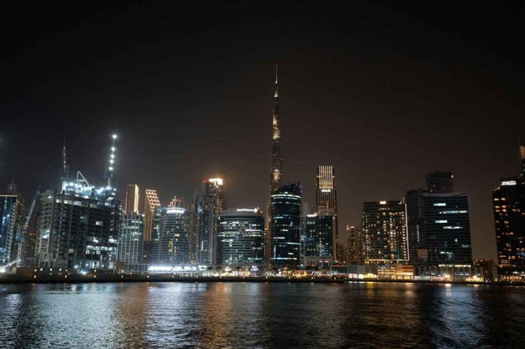 Foto do horizonte de uma cidade com vários prédios iluminados durante a noite