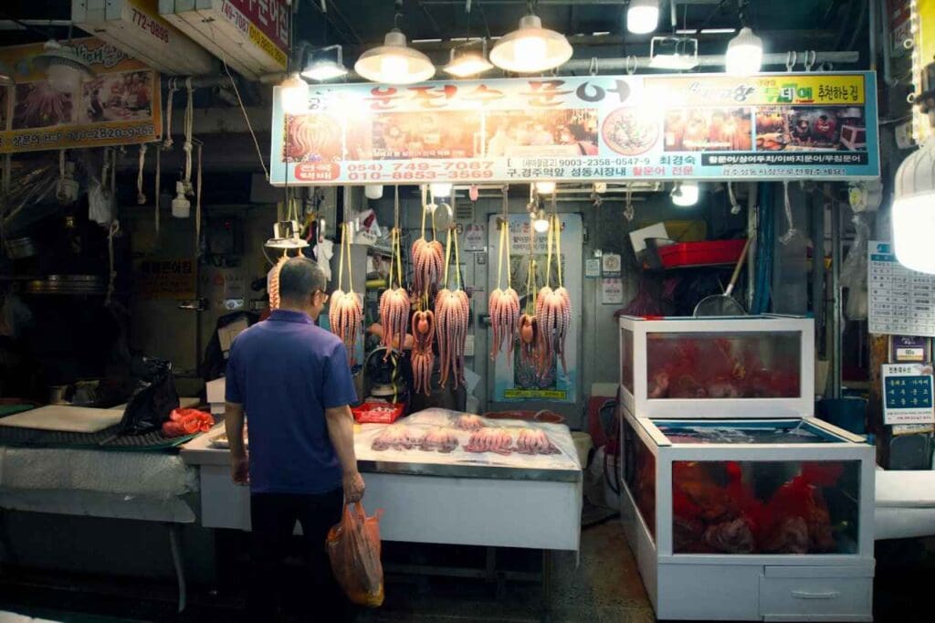Foto de um homem em frente a uma barraca de comida